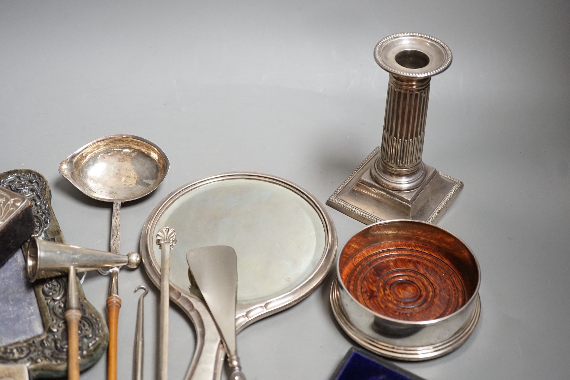 A group of small silver including two mounted photograph frames, one Birmingham, 1901, a mounted bible case, candlestick snuffer, coaster, etc.